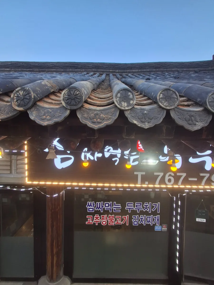 출입구 위 한식기와 처마선을 고르게 맞춰 마감한 시공 후 모습