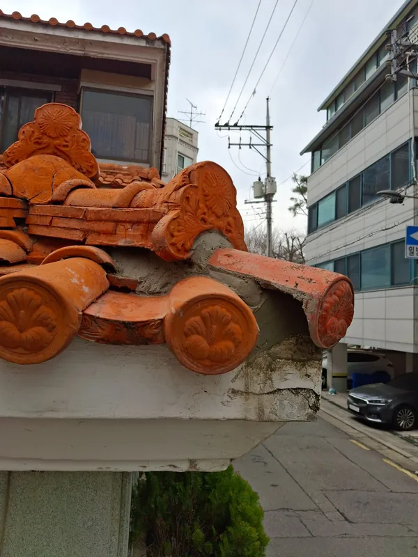 용마루 끝과 모서리 기와를 모르타르로 보수한 상태
