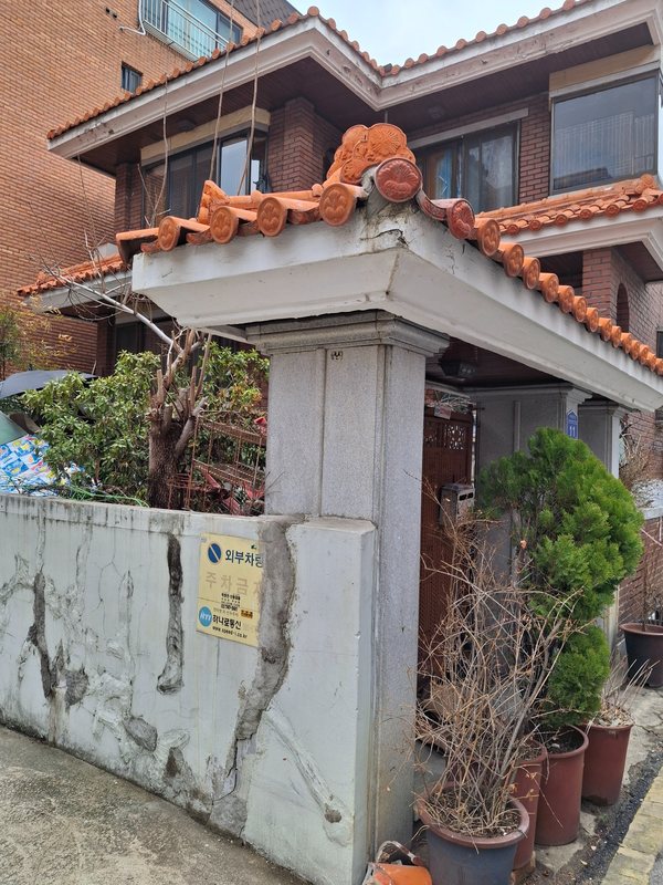 붉은 장식기와와 마루 끝을 다시 맞추고 주변 마감을 정리한 기와마감보수 완료 상태